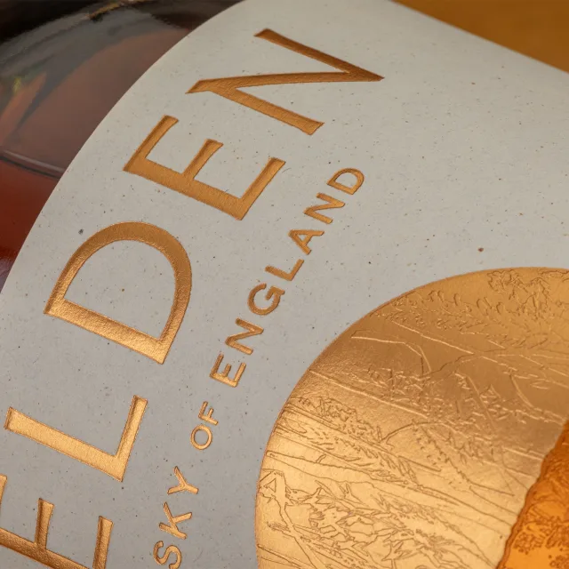 Premium whisky label with textured paper, gold foil embossing and luxury finishing on a whisky bottle.